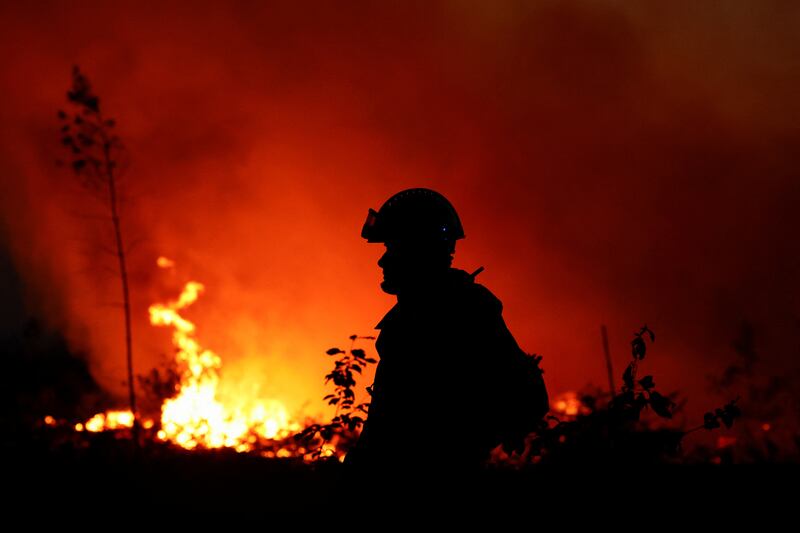 A firefighter is silhouetted by flames in Louchats, in the Gironde region of south-west France. Reuters