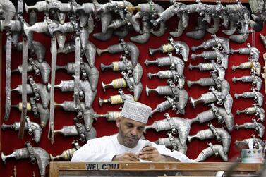 An Omani  sits in front of a display of jambiyas (traditional daggers) in Muttrah Souq, the oldest market in Oman, in the capital, Muscat  Reuters