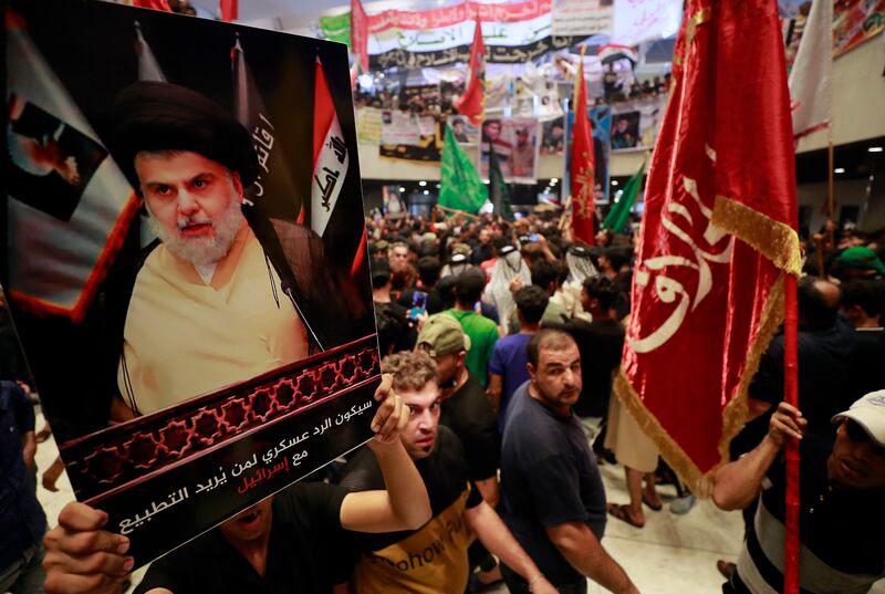 Supporters of Moqtada Al Sadr hold up a poster of the populist Iraqi cleric during a protest in parliament on August 2. AFP