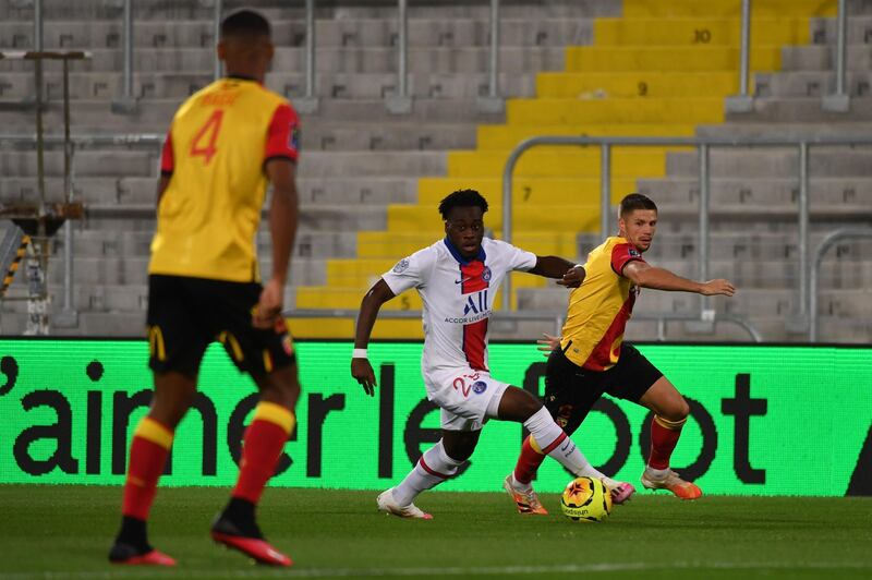 Paris Saint-Germain's forward Arnaud Kalimuendo, centre, fights for the ball with Lens' midfielder Manuel Perez at the Felix Bollaert-Delelis stadium in Lens on Thursday. AFP