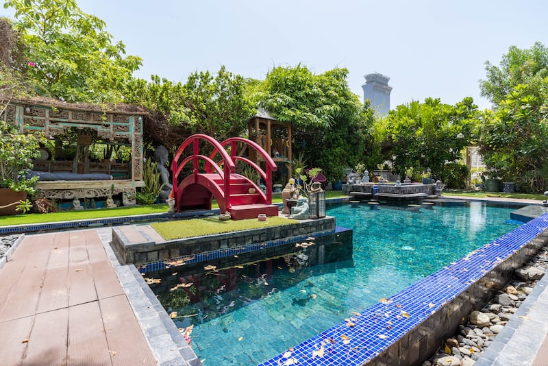 The property is set in Palma Residences. The pool is surrounded by sculptures while a red bridge adds a pop of colour