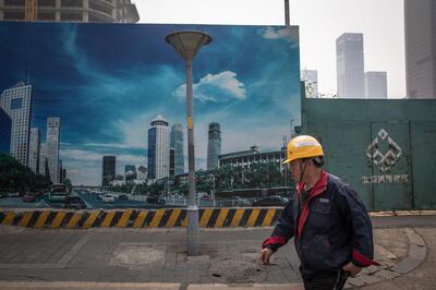 epa07511344 A Chinese worker walks near a construction site in the Central Business District (CBD) area in Beijing, China, 17 April 2019. China reported a 6.4 percent growth in the first quarter GDP (gross domestic product), compared to the last year.  EPA/ROMAN PILIPEY