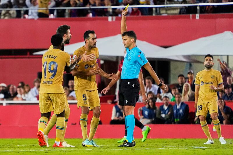 Referee Jesus Gil Manzano shows a yellow card to Barcelona defender Gerard Pique. Getty