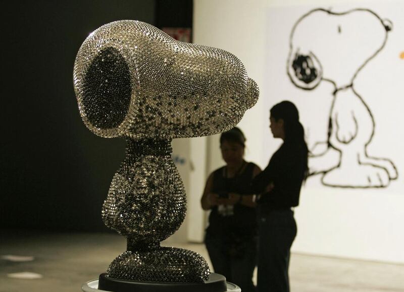 People stand near a Snoopy sculpture created by a Mexican artist and on display during the Snoopy visits Guadalajara event at a gallery in Guadalajara on 2 May, 2014. The event is part of a charity initiative to support women from Chiapas and their culture, which will run until 17 May, 2014. Reuters