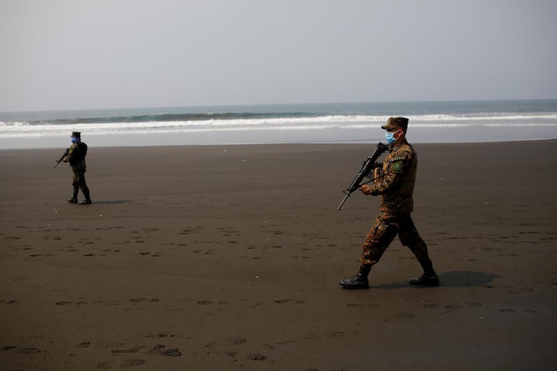 Salvadoran soldiers walk during a patrol at El Majahual beach during a quarantine throughout the country, as the government undertakes steadily stricter measures to prevent the spread of Covid-19, in La Libertad, El Salvador. Reuters
