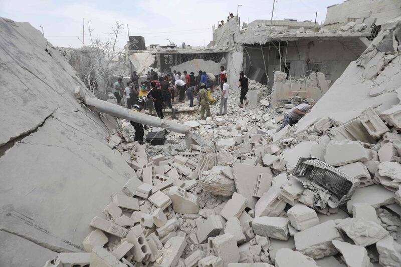 Syrian rescue teams and civilians search for survivors amid the rubble in a freshly bombarded area following a reported air strike by regime forces and their allies on the market town of Kfar Ruma in Syria's southwestern Idlib province, on May 30, 2019. Regime forces and their Russian allies have over the past three months escalated bombardment of Syria's last major jihadist bastion in the province of Idlib and adjacent areas. / AFP / OMAR HAJ KADOUR
