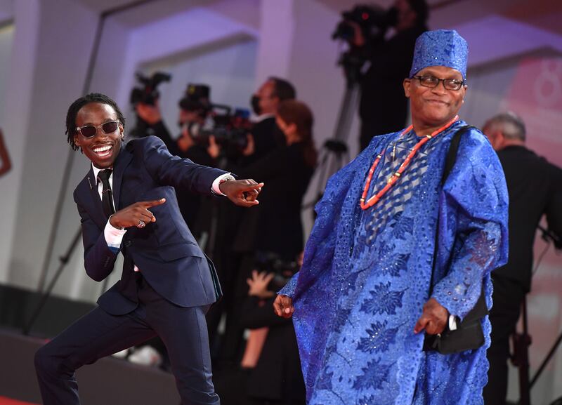 Actor Michael Ajao, left, joined by his father in traditional dress, attends the red carpet for 'Last Night In Soho' during the 78th Venice International Film Festival on September 4, 2021. EPA