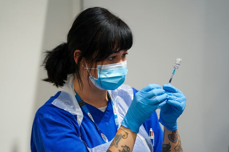 A member of staff prepares a Covid-19 vaccine at a pop-up vaccination centre at Westfield Stratford City shopping centre in east London. PA
