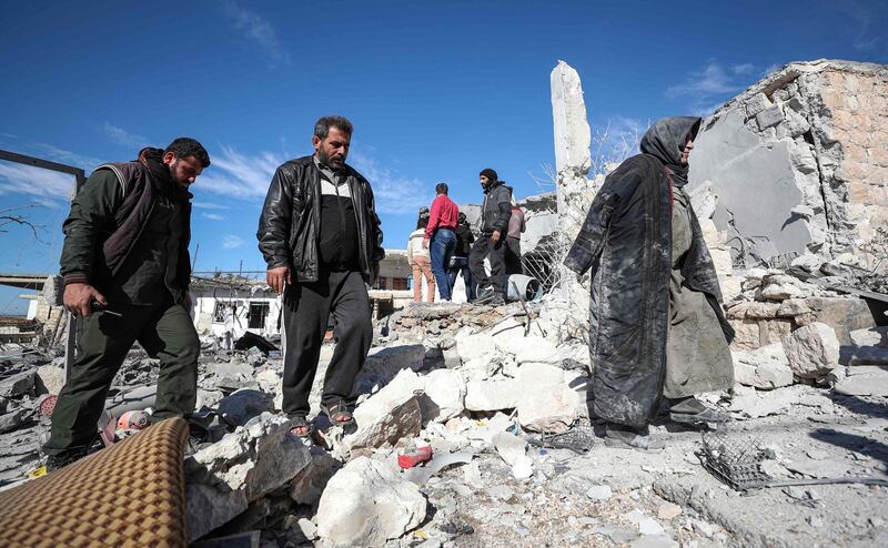 A Syrian woman (R) who returned to her town of Kafr Ruma in the south of the northwestern Idlib to collect belongings walk through rubble in the town following a reported air strike on December 3, 2019.  / AFP / Omar HAJ KADOUR
