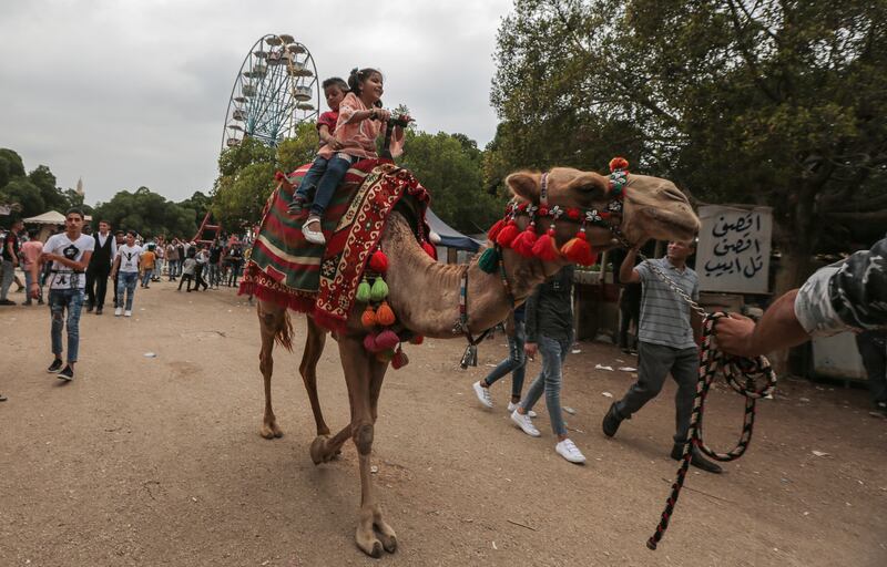 epa06962790 Children ride a camel at the popular amusement park 'Horsh Beirut' to celebrate Eid Al-Adha in Beirut, Lebanon, 21 August 2018. Eid al-Adha is the holiest of the two Muslims holidays celebrated each year, it marks the yearly Muslim pilgrimage (Hajj) to visit Mecca, the holiest place in Islam. Muslims slaughter a sacrificial animal and split the meat into three parts, one for the family, one for friends and relatives, and one for the poor and needy.  EPA-EFE/NABIL MOUNZER *** Local Caption *** 54566962