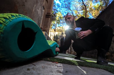 Ibrahim Abougendy, founder of the eco-friendly design studio Mobikya puts food for stray cats at his designed upcycled mobile shelters made out of old tyres to keep them warm during winter in Cairo, Egypt January 13, 2022.  Picture taken January 13, 2022.  REUTERS / Amr Abdallah Dalsh