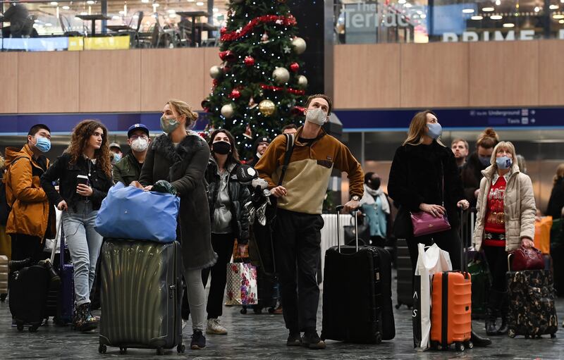 Travellers wait for trains on the eve of Christmas, at Euston Station in London. EPA