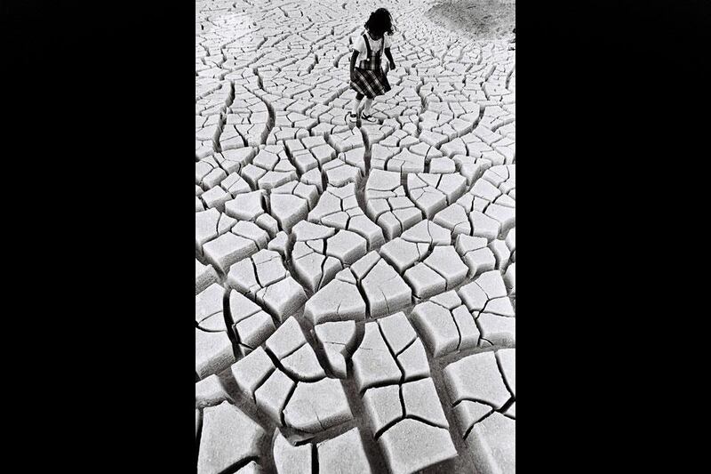 On land near where the Emirates Palace now stands in Abu Dhabi, a young girl plays hopscotch on the fractured, arid ground. Courtesy Al Ittihad