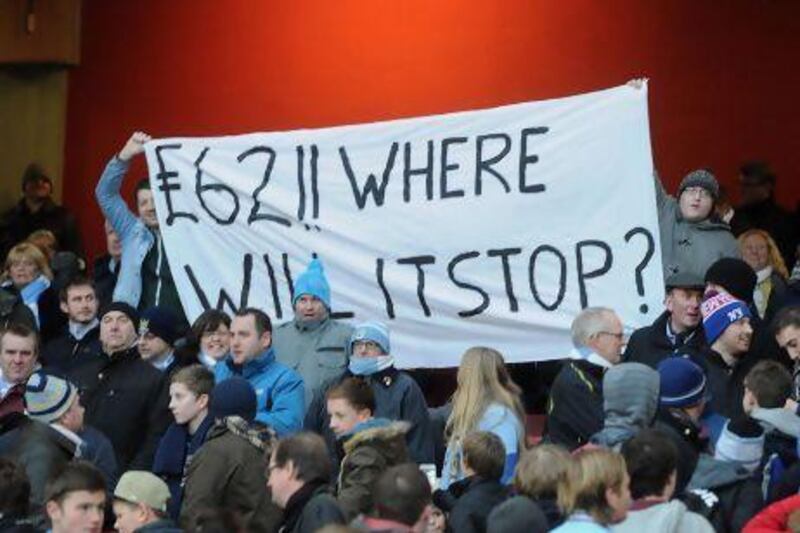 Fans hold a banner in the stands relating to the price of tickets during the Barclays Premier League match at The Emirates Stadium, London.