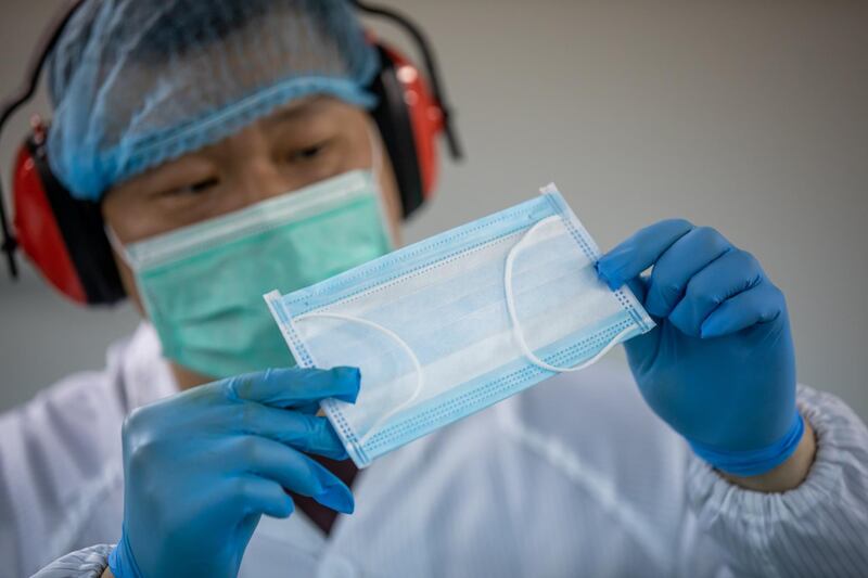 A worker inspects a protective mask on the production line at the Mask Factory Co. facility in Hong Kong, China.  Bloomberg