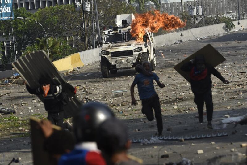 Flames and smoke rise from an armored vehicle during clashes between protesters and members of the National Bolivarian Armed Forces after an attempted military uprising on Francisco Fajardo Highway in Altamira, Caracas, Venezuela, on Wednesday, May 1, 2019. One day after an attempt to spark a military uprising fell flat, Venezuela's opposition was at it again Wednesday, making another desperate effort to rally residents to oust President Nicolas Maduro. Photographer: Carlos Becerra/Bloomberg