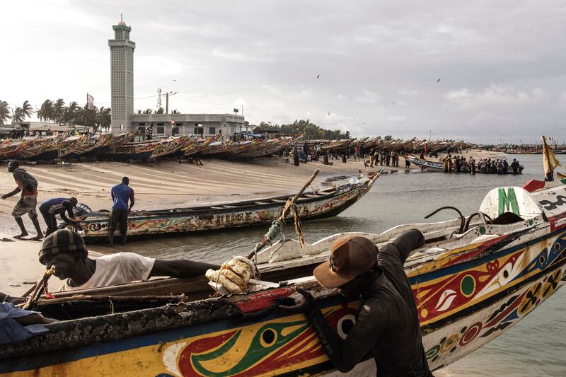 Fishermen haul their pirogues ashore after a day's fishing in Djiffer, Senegal. AFP