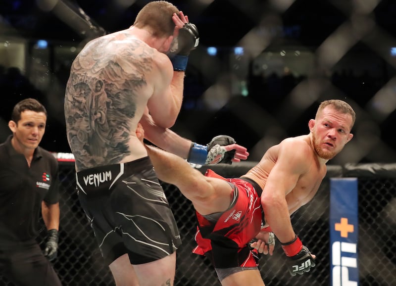 Cory Sandhagen (blue) takes a kick from Petr Yan (red) at UFC 267.