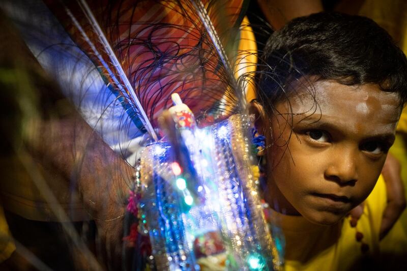 A Hindu boy carries a Kavadi offering cages in a procession during the Thaipusam festival at Batu Caves, outskirts of Kuala Lumpur. AP Photo
