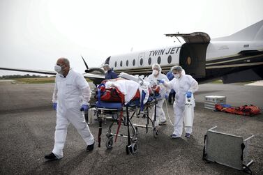 Medical workers carry a patient suffering from Covid-19 during a transfer operation from Lille to Vannes, France. Reuters 