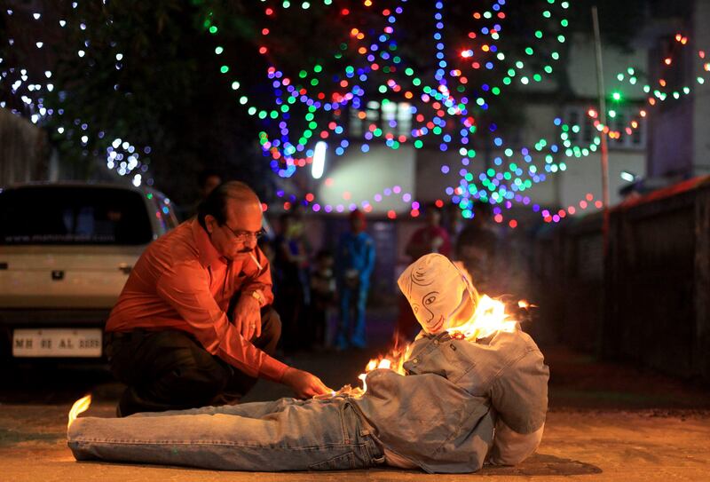 A man lights an Old Man effigy which symbolizes burning the past and getting ready to start a happy New Year without bad memories of the past in Mumbai, India, Sunday, Jan. 1, 2012.(AP Photo/Rafiq Maqbool) *** Local Caption ***  India New Year.JPEG-03fb4.jpg