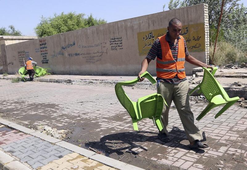 Iraqi municipality workers clean the scene of a suicide attack in Baghdad's western Eskan neighbourhood, Iraq, Sunday, Sept. 25, 2016. A suicide bomber killed several people who were setting up tents on Sunday ahead of a major Shiite religious observance next month, officials said. (AP Photo/Hadi Mizban)