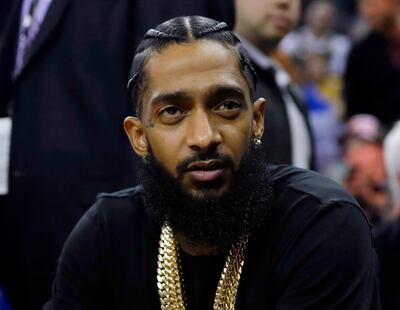 FILE - This March 29, 2018 file photo shows rapper Nipsey Hussle at an NBA basketball game between the Golden State Warriors and the Milwaukee Bucks in Oakland, Calif. Hussle, who was shot and killed outside of his clothing store in Los Angeles on March 31, 2019, is nominated for three Grammy Awards, His song â€œRacks In the Midldle is up for best rap performance and best rap song, while â€œHigher,â€ a collaboration with DJ Khaled and John Legend that one of the last songs Hussle recorded, is nominated for best rap/sung performance. (AP Photo/Marcio Jose Sanchez, File)