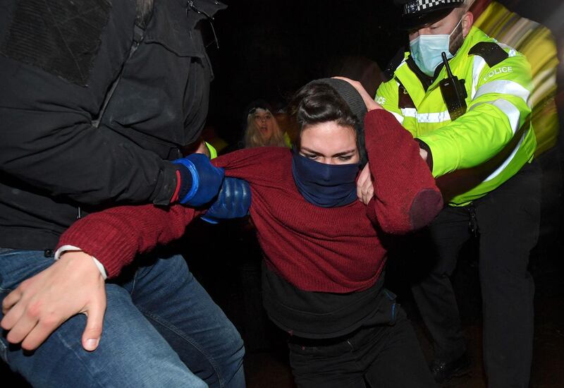 Police scuffle with people gathering at the Clapham Common bandstand,  London, as officers try to clear the area. AFP