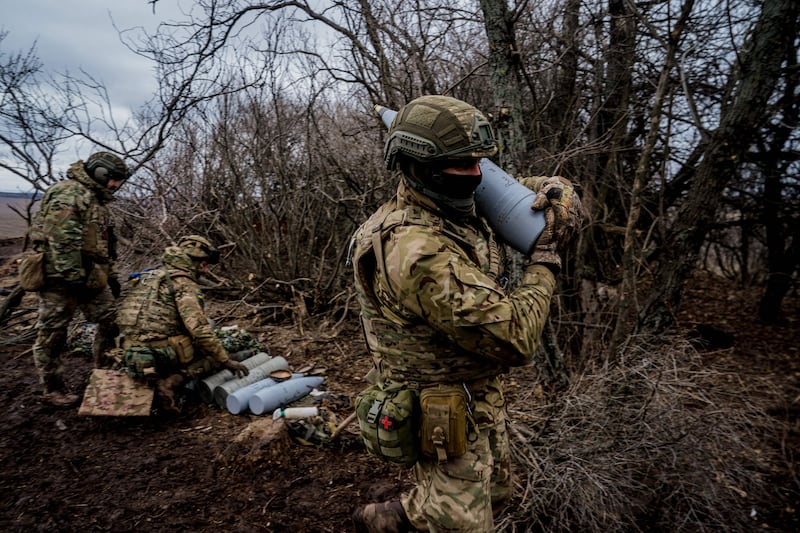 A Ukrainian serviceman near Bakhmut carries a 152mm shell to fire a Msta-B howitzer towards Russian positions.  AFP