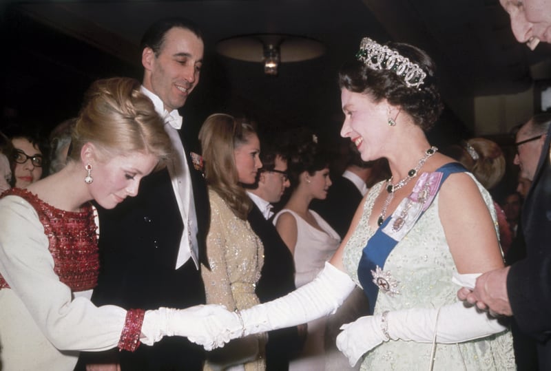Queen Elizabeth II meets French actress Catherine Deneuve at a Royal film Performance, on March 14, 1966. Getty Images