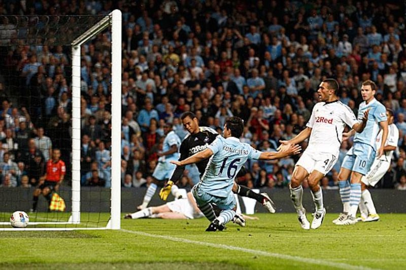 Sergio Aguero slots in his first ever Premier League goal to double Manchester City's lead against Swansea.

Jon Super / AP Photo