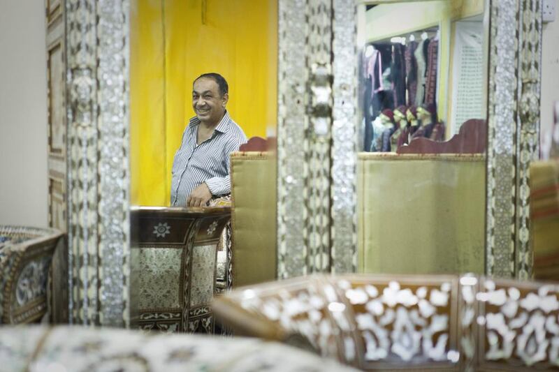 Dib Baghdadi, a salesman from Syria stands at his stall at the Syrian pavilion of Global Village. He sells ornamental furniture made from seashells. Razan Alzayani / The National