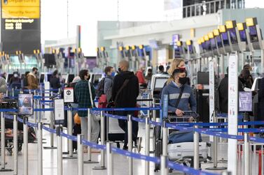 Passengers wait at check-in desks in the departures hall in Terminal 5 at London Heathrow Airport. Bloomberg