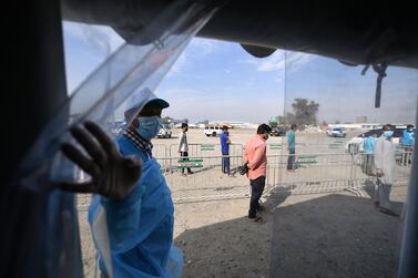 UAE residents stand in line as they wait to be checked for the novel coronavirus at a testing centre in the Al Quoz area of Dubai, on April 18, 2020. AFP