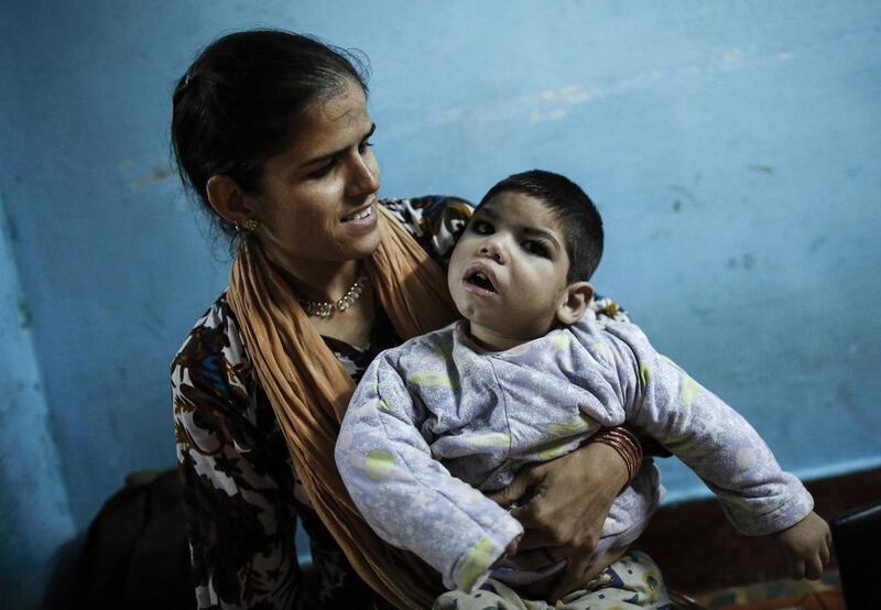 Three-year-old Abdul, who suffers from mental and physical disabilities plays with his mother Rukhsana at their house in Bhopal.