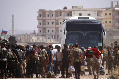 Syrian rebels and their families stand by buses to be evacuated from Daraa city, on July 15, 2018, as Syrian government forces heavily bombed the neighbouring province of Quneitra making a ground advance in the zone.  
 


 Syrian rebels and their relatives began evacuating the southern city of Daraa today under a deal to bring the "cradle" of the country's uprising back into the government's fold. / AFP / Mohamad ABAZEED
