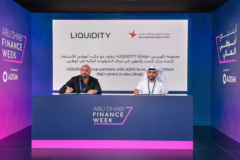 Abdulla AlShamsi, acting director general of Adio, right, signs the agreement with Ron Daniel, chief executive of Israel's Liquidity Group. Photo: Adio