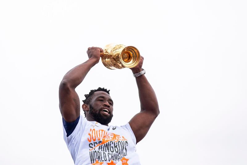 South African Rugby captain Siya Kolisi celebrates and holds up the Web Ellis Trophy as the South African Rugby World Cup winner team parades on an open top bus through the streets of the city of Zwide , Port Elizabeth. AFP