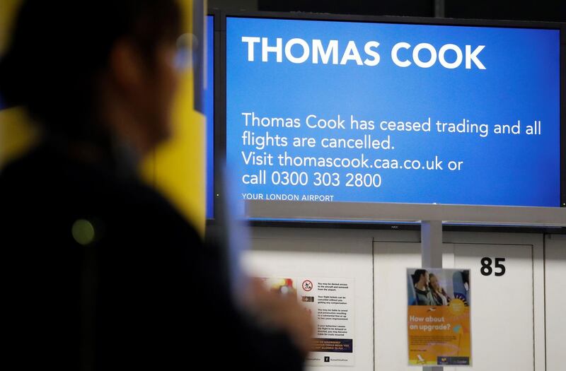 Passengers walk past the closed Thomas Cook check-in desks at the South Terminal of London Gatwick Airport in Crawley, south of London on September 23, 2019, after the company announced it was taking steps to enter into compulsory liquidation with immediate effect. British travel firm Thomas Cook collapsed into bankruptcy on Monday, leaving some 600,000 holidaymakers stranded and sparking the UK's biggest repatriation since World War II. The 178-year-old operator, which had struggled against fierce online competition for some time and which had blamed Brexit uncertainty for a recent drop in bookings, was desperately seeking £200 million ($250 million, 227 million euros) from private investors to avert collapse.
 / AFP / Tolga AKMEN
