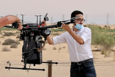 Ahmed Borik, IoT systems engineer, with the Cafu drone during a press conference at the Sanad Academy, Skyhub RC Club in Dubai. Cafu is using drones to plant 1 million ghaf seeds in the UAE. Pawan Singh / The National