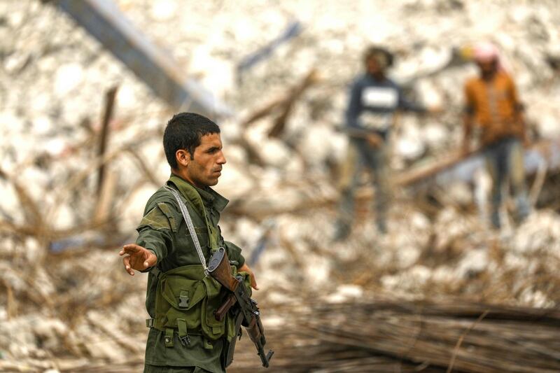 A member of the Raqa civil council's local security forces gestures to a vehicle at a checkpoint securing vehicles entering into the eastern Syrian city and former Islamic State (IS) group stronghold. A year after Kurdish and allied forces drove the Islamic State group from the northern Syrian city of Raqa, traumatised civilians still live in fear of near-daily bombings. AFP