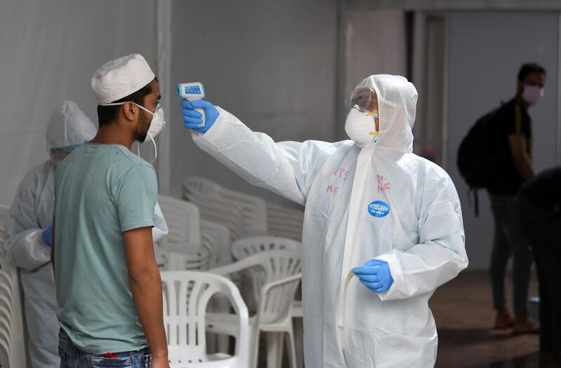 A foreign worker gets his body temperature tested for the novel coronavirus at a testing centre in the Naif area of the Gulf Emirate of Dubai, on April 15, 2020.  / AFP / KARIM SAHIB
