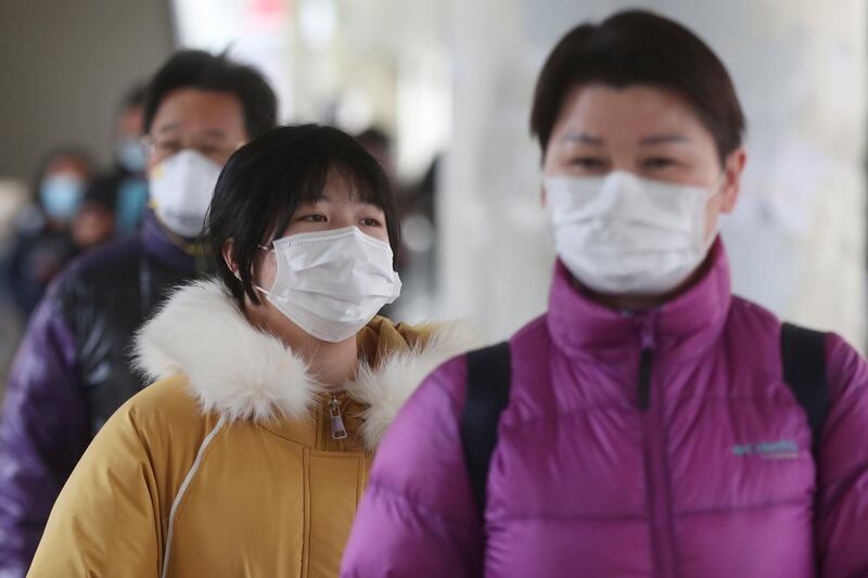 People wear face masks walk in Hong Kong. AP Photo