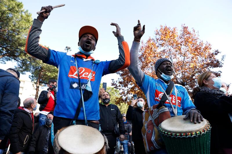 Men dressed in Napoli shirts carry drums and mourn the death if Diego Maradona. Reuters