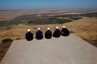 TOPSHOT - Druze men at the Israeli-annexed Golan Heights look out across the southwestern Syrian province of Quneitra, visible across the border on July 7, 2018  / AFP / JALAA MAREY
