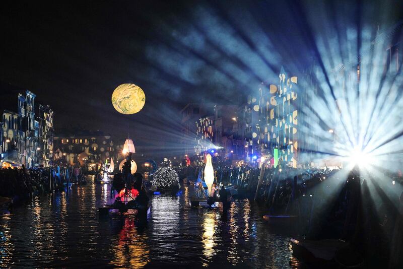 Artists perform during the 'Tutta colpa della Luna' or 'Blame the Moon' festivities down the Rio di Cannaregio, one of Venice's famed canals on February 16, 2019.  Venice began its annual Carnival festivities with a floating, night-time parade starting more than two weeks of celebrations to mark 50 years since man first walked on the moon. / AFP / Vincenzo PINTO
