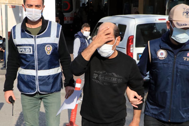 Syrian singer Omar Souleyman escorted by Turkish policemen as he leaves a hospital in Sanliurfa on November 18, 2021.  AFP