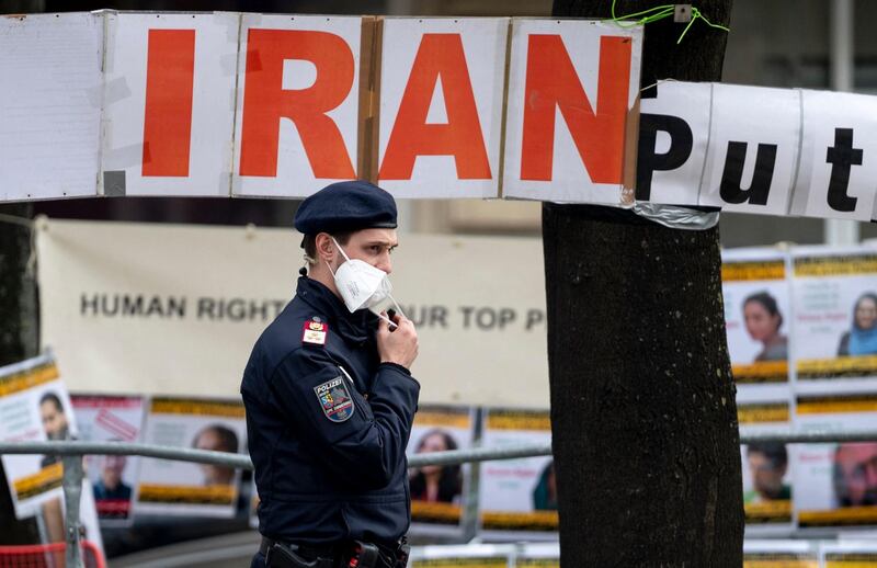 A police officer patrols in front of banners put up by members of the National Council of Resistance of Iran, an Iranian opposition group, in front of the 'Grand Hotel Wien' during the closed-door nuclear talks with Iran in Vienna on April 27, 2021, where diplomats of the UK, EU, China, Russia and Iran hold their talks. A third round of negotiations opens on April 27 in Vienna in an attempt to salvage the Iran nuclear deal, a new stage in the rocky discussions to get Iran and the United States back on track. 
 / AFP / JOE KLAMAR
