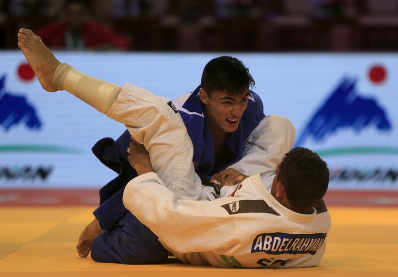 Denislar Ivanov, in blue from Bulgaria, fights with Ahmed Abelrahman from Egypt on the opening day of the International Judo Federation (IJF) Junior World Championships, which started at the Ipic Arena at the Zayed Sports City in Abu Dhabi on Friday. Ravindranath K / The National