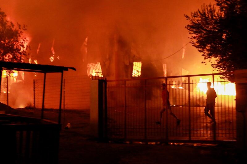 A man runs as a fire burns inside the Moria migrant camp on the island of Lesbos.   AFP